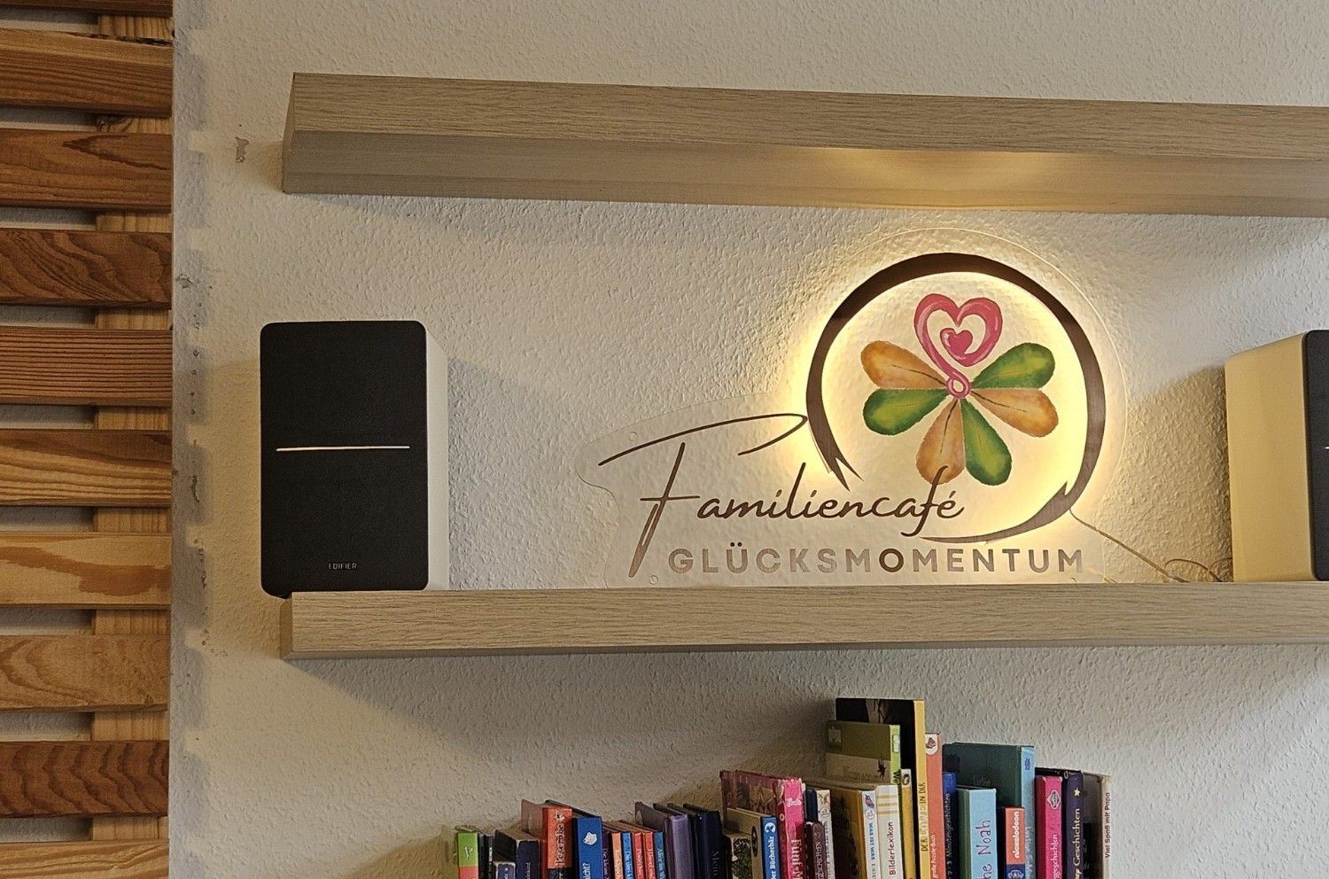 Ein Regal mit verschiedenen Büchern und zwei Lautsprechern darauf.