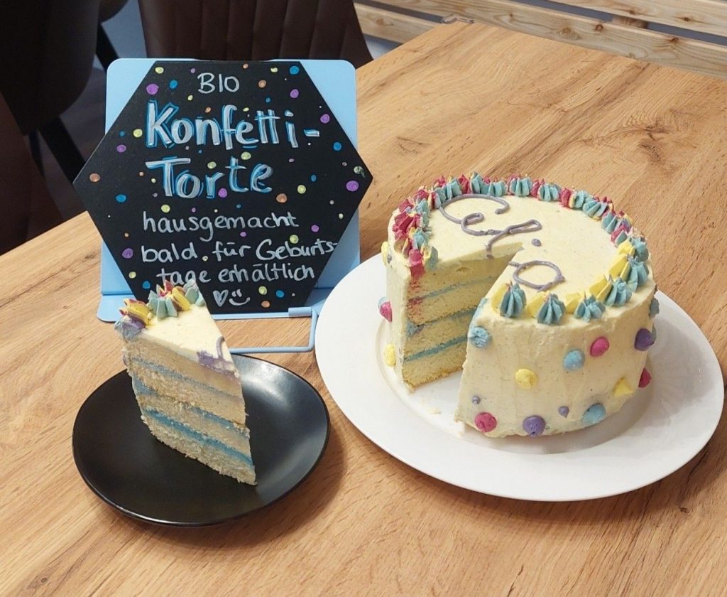 Bunte Konfetti-Torte mit Stück